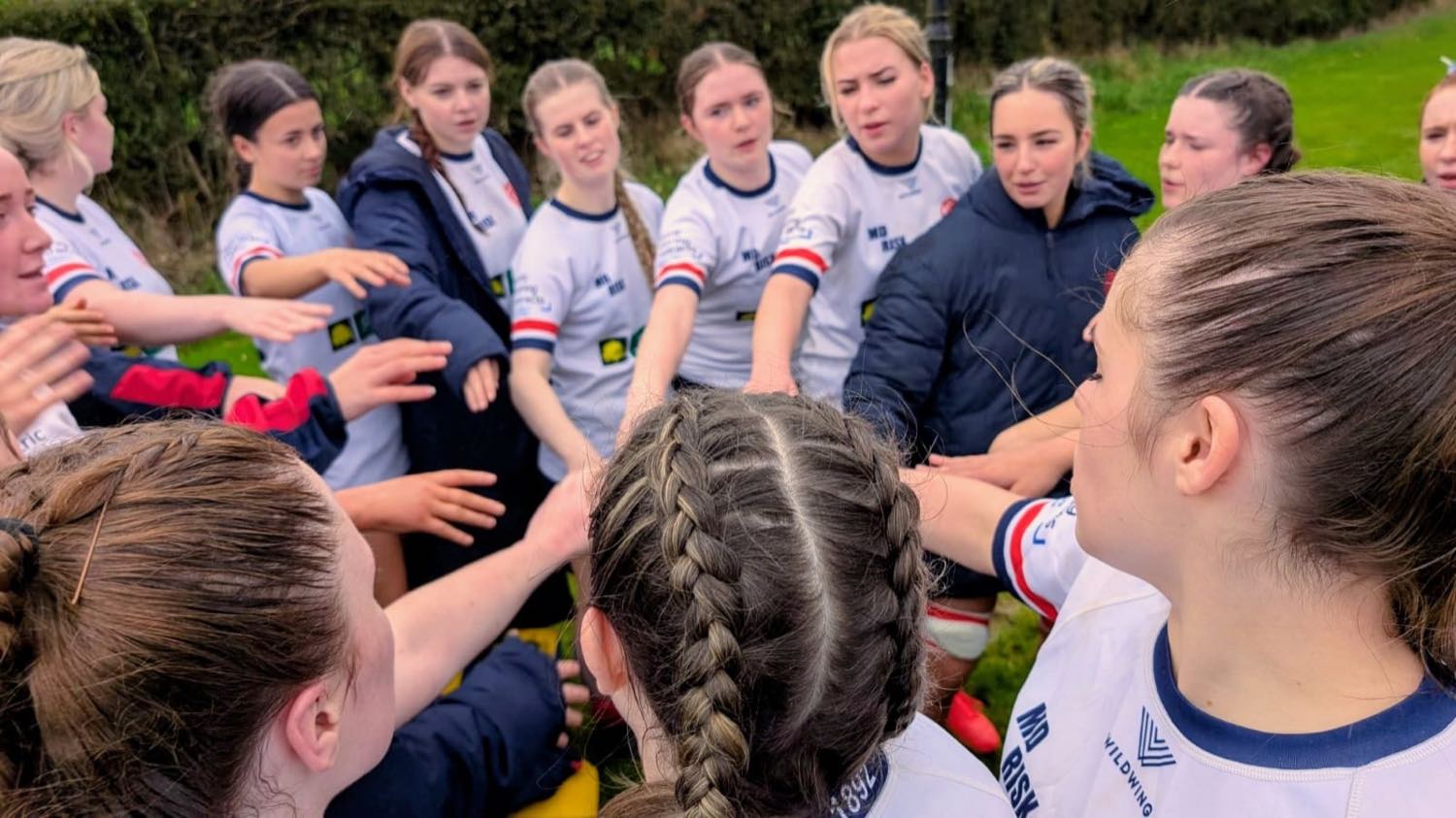 Malone youth players in a team huddle